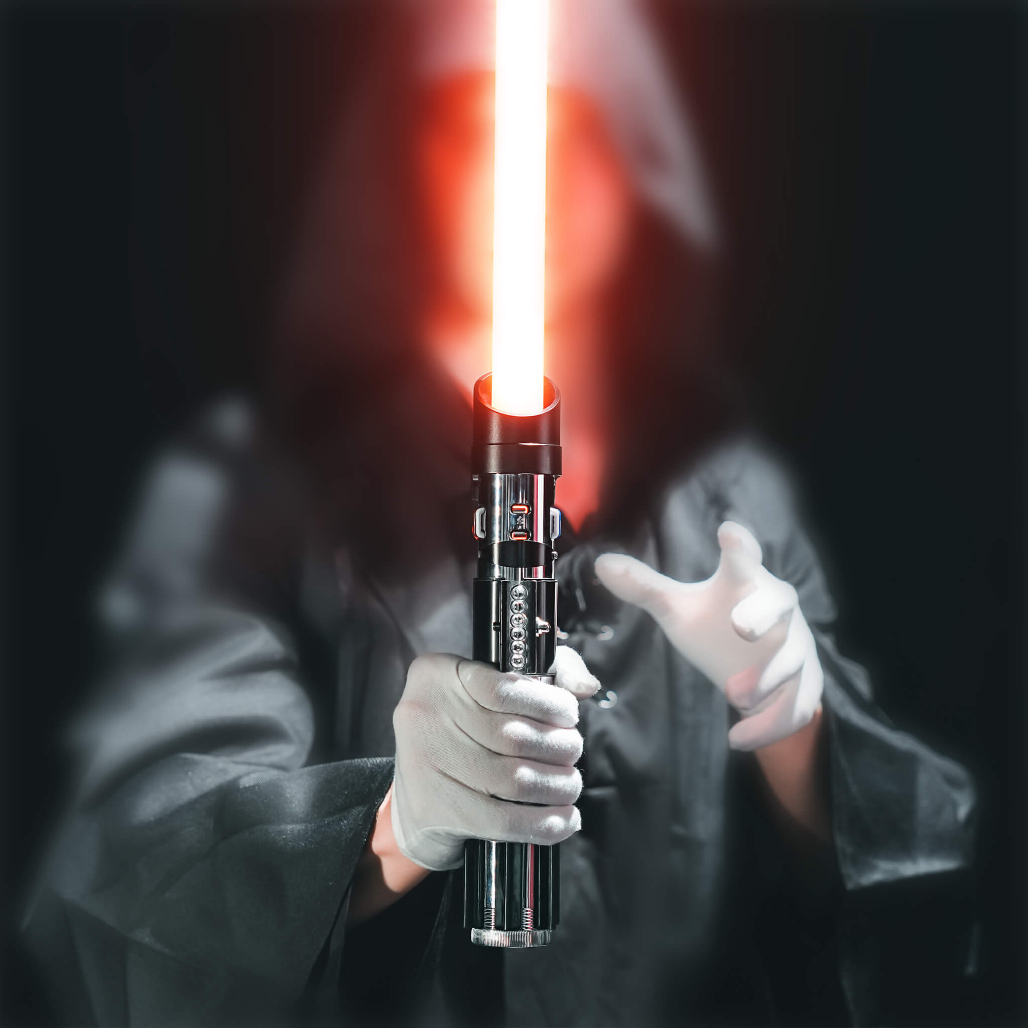 Cosplayer in a dark hooded robe holding a lighted Darth Vader replica saber, cinematic star wars cosplay photography.