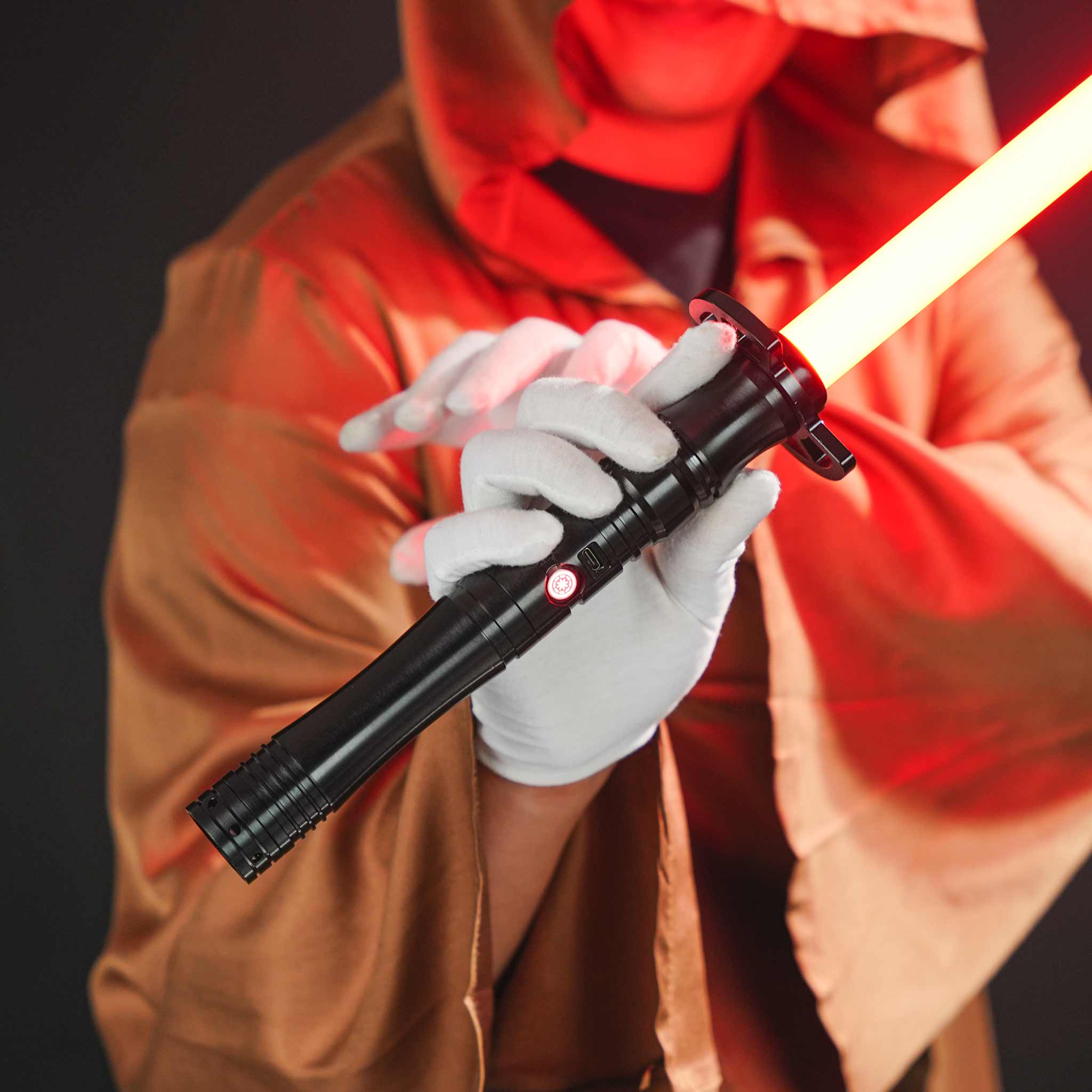 Cosplayer wearing a brown robe holding the premium black metal lightsaber hilt in hand
