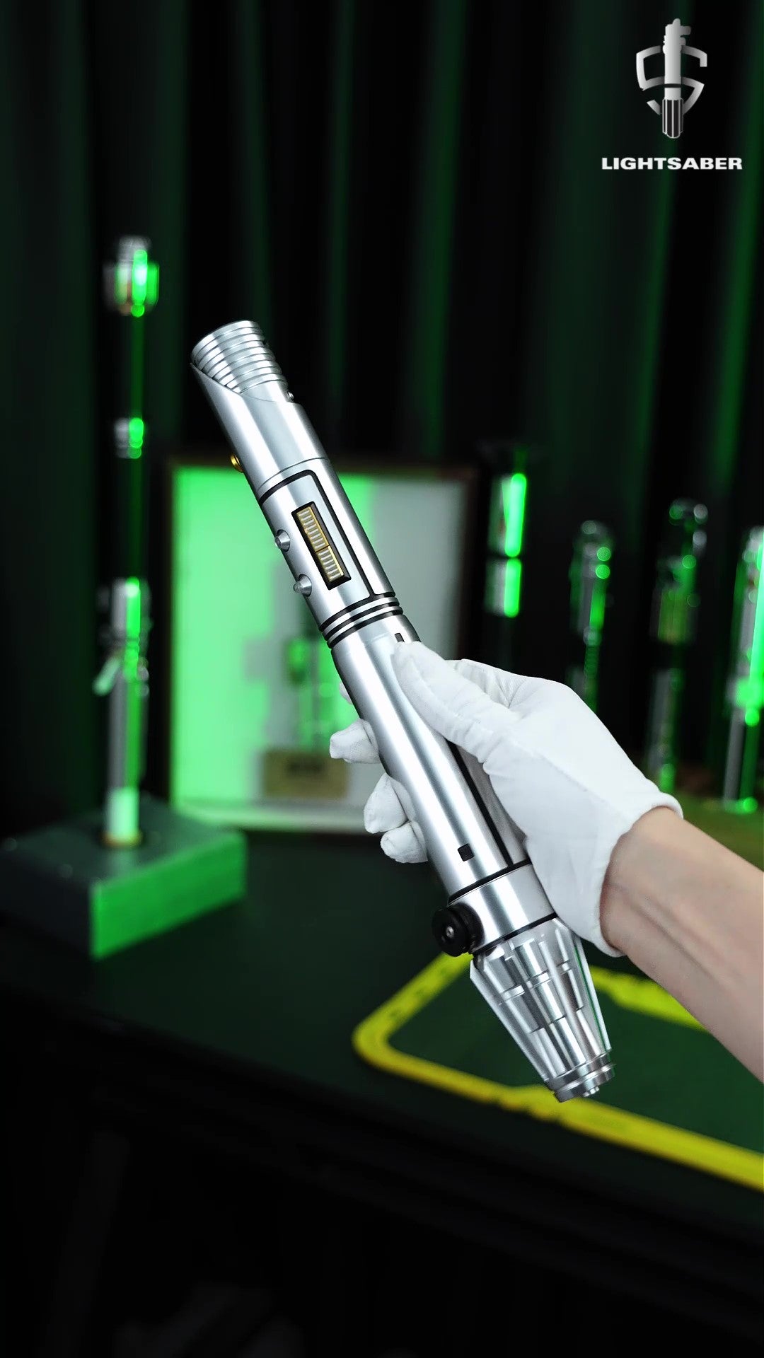 A close-up product demonstration video of the LIGHTSABER® Master Kelleran Beq Saber, showcasing its metallic hilt design, glowing green Pixel blade, and smooth swing motion control effects.